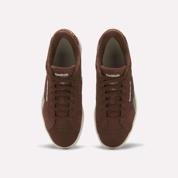 A pair of Reebok Club C Grounds UK Shoes in brown suede viewed from above, with white soles, laces, and Reebok branding on the tongue and side, delivering a classic vintage tennis style.