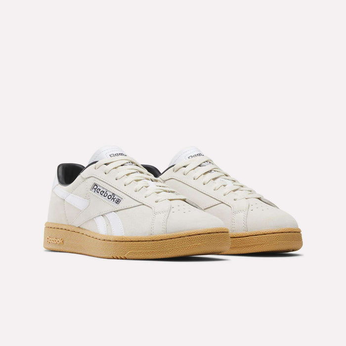 The Reebok Club C Grounds UK Shoes feature premium off-white suede uppers, white side stripes, black heel accents, and gum rubber soles, shown against a plain white background for a classic style look.