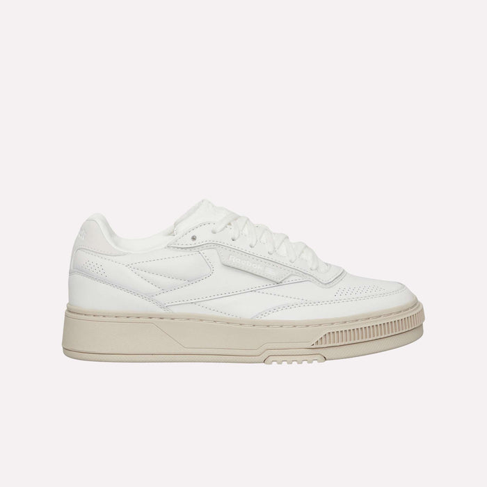 A true lifestyle classic inspired by the iconic Club C silhouette, the Reebok Club C LTD Shoes feature a white low-top design with a beige sole, white laces, and subtle stitched detailing on the sides, all showcased against a plain white background.