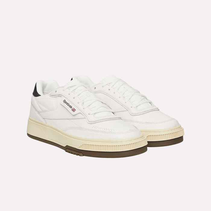 A pair of Reebok Club C LTD Shoes in white with off-white soles and black heel accents, showcased on a plain white background for a refined update to this lifestyle classic.