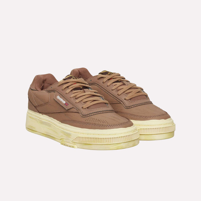 A pair of Reebok Club C LTD Shoes in brown with beige soles, displayed side by side on a light background, perfectly embodies the timeless appeal of this classic lifestyle tennis shoe.