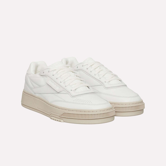 A pair of Reebok Club C LTD Shoes, featuring a white low-top design with off-white soles, laces, and stitching details that capture a classic lifestyle aesthetic reminiscent of the iconic Club C style, displayed on a plain white background.