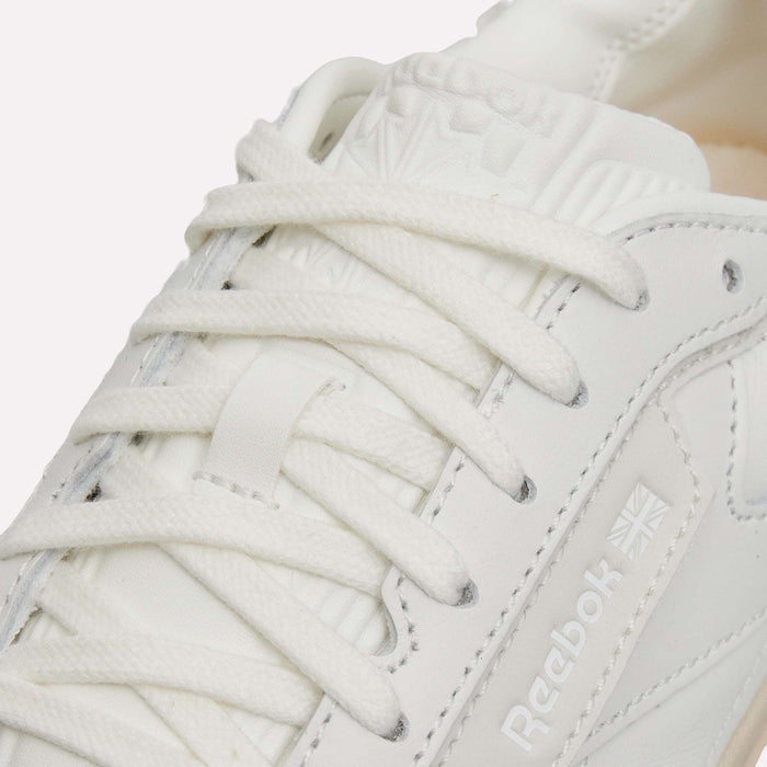 Close-up of a white Reebok Club C LTD Shoe, featuring classic laces, perforated details, and the Reebok logo with a small Union Jack on the side panel.