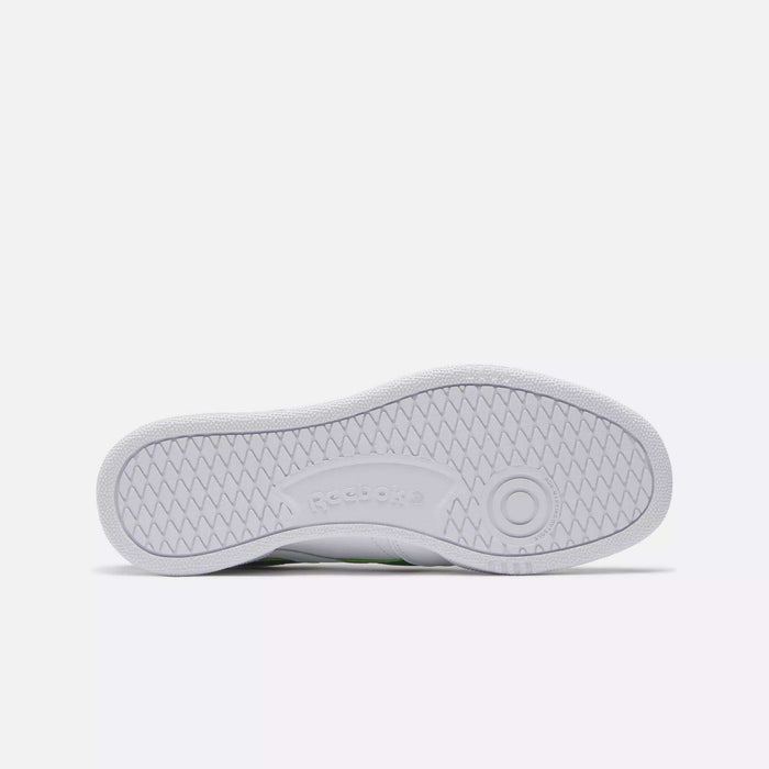 The image displays the white rubber sole of a Reebok Club C Revenge Shoes, viewed from below. It features a herringbone tread pattern and an embossed Reebok logo at the center.