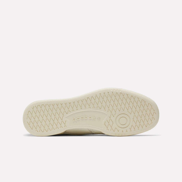 The image displays the sole of Reebok’s Club C Revenge Vintage Shoes in off-white, highlighting a herringbone tread pattern and a central Reebok logo—a classic detail inspired by vintage style.