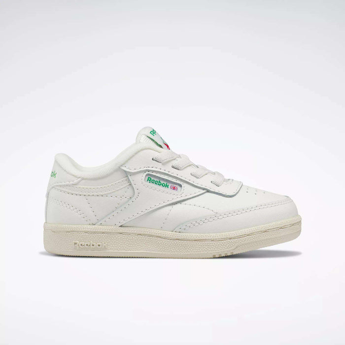 The Reebok Kids' Club C Shoes for baby & toddler are white with green and red accents, classic '80s style, and feature the Reebok logo on the side and tongue, shown in a sleek profile on a plain white background.