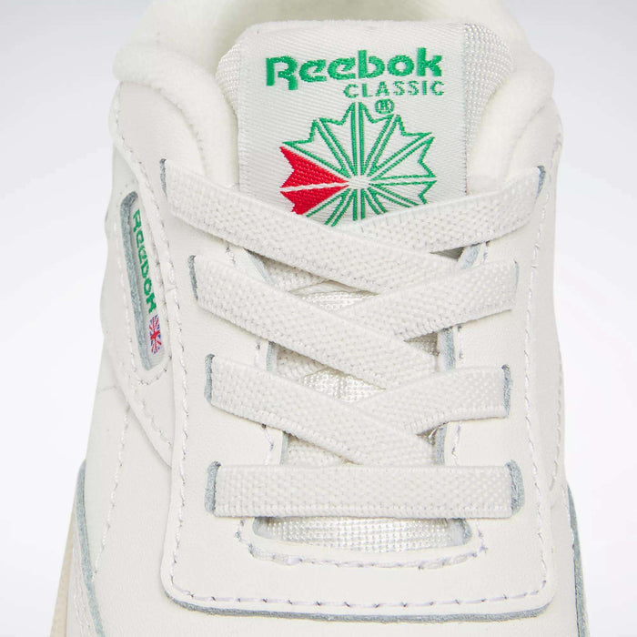 Close-up of Reebok Kids' Club C Shoes for babies and toddlers, featuring '80s-inspired details like the green and red tongue logo, white laces, and side label with the Reebok name and Union Jack flag—ideal for classic sneaker fans.