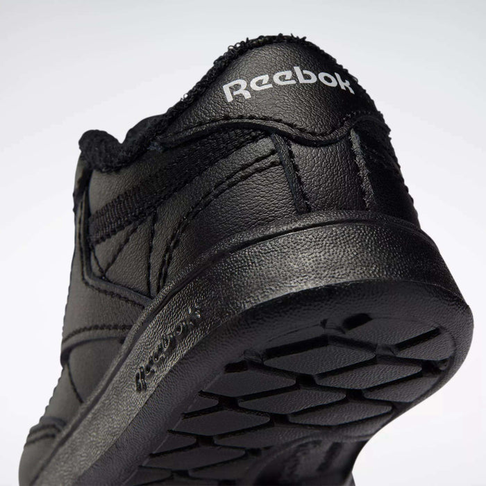 Close-up of the heel and sole of a black Reebok Kids' Club C Shoe for babies and toddlers, featuring soft leather, the Reebok logo on the heel, and textured sole patterns. The shoe is tilted upward against a plain light background.
