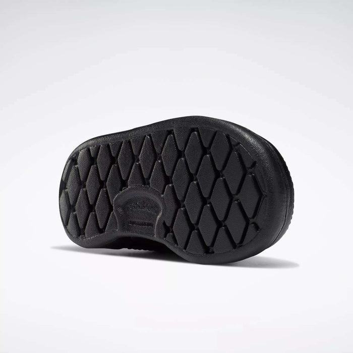 Black rubber sole with diamond-shaped tread, viewed from below on a white background. Made for Reebok Kids' Club C Shoes - Baby & Toddler, it features a rounded shape and subtle branding near the arch.