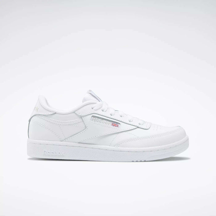 The Kids' Club C Shoes – Grade School by Reebok are white low-top sneakers with soft leather uppers, the Reebok logo, and a small Union Jack flag on the side, shown on a plain white background.