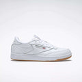 The Reebok Kids' Club C Shoes - Grade School feature soft white leather uppers, a gum sole, side branding, and perforated accents, displayed on a plain light gray background.