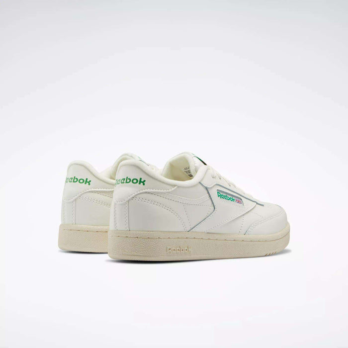Reebok Club C Shoes - Big Kids are classic white sneakers with green logo accents, clean lines, off-white soles, and a minimalistic '80s-inspired design, shown angled on a plain light background.