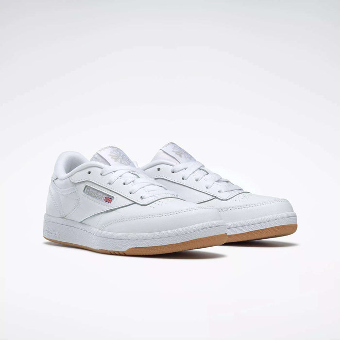 The Reebok Kids' Club C Shoes - Grade School feature classic white soft leather uppers, gum soles, and display the Reebok logo with a British flag on the side, shown against a plain white background.