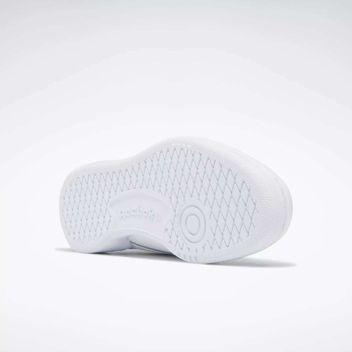 The image shows the white sole of the Kids' Club C Shoes - Grade School by Reebok, featuring a textured diamond pattern, a circular design near the heel, and an embossed Reebok logo in the center of the high-abrasion rubber outsole.