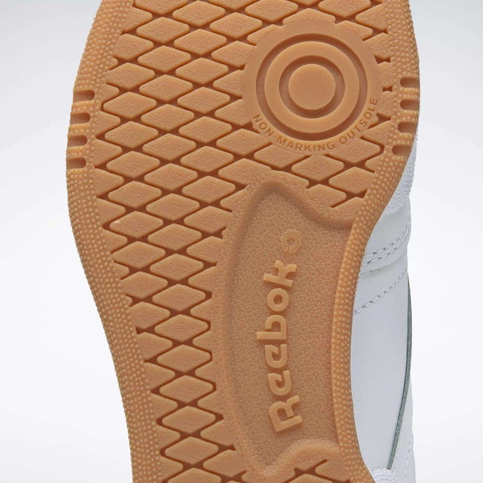 Close-up of a tan Reebok Kids' Club C Shoes - Grade School sole, showing the honeycomb tread, circular detail, Reebok logo, high-abrasion rubber outsole, and "NON MARKING OUTSOLE" text.