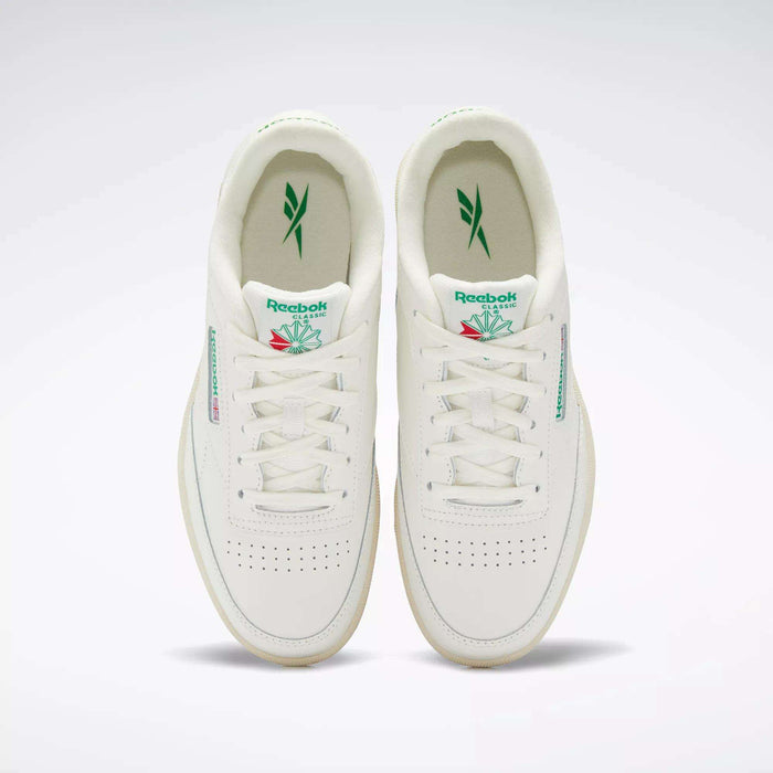The Reebok Club C Shoes for big kids are white sneakers with green accents, featuring the Reebok logo on the tongue and side, plus perforated toe boxes for classic '80s style.