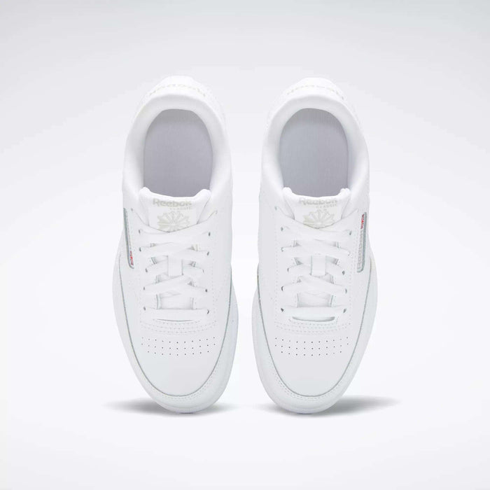 A top view of the Reebok Kids' Club C Shoes - Grade School shows classic white leather uppers, white laces, perforated toe boxes, and subtle Reebok branding against a plain light background.