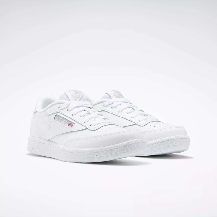 A pair of Reebok Kids' Club C Shoes for grade school, featuring classic low-top style, soft leather uppers, the Reebok logo, and a small Union Jack flag on the side, shown on a white background.