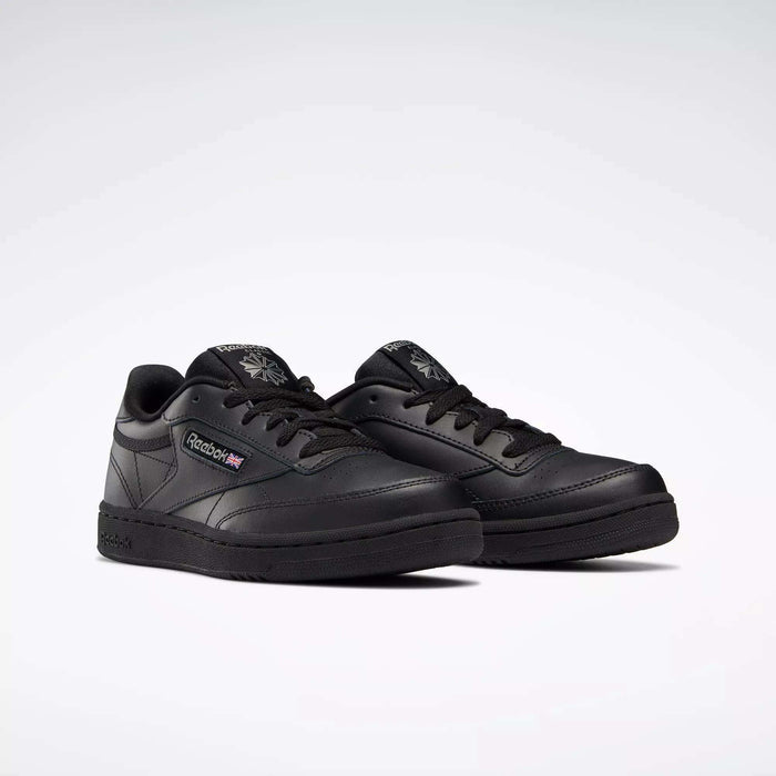 A pair of Reebok Kids' Club C Shoes - Grade School with black leather uppers, black soles and laces, the Reebok logo and a small Union Jack on the side, displayed on a plain white background.