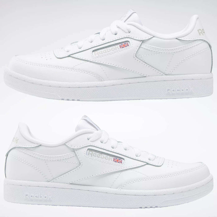 Two white Reebok Kids' Club C Shoes for grade school are shown side by side, highlighting soft leather uppers, subtle Reebok branding with the Union Jack flag, stitching details, and a plain light-colored background.