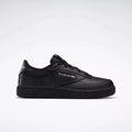 The Kids' Club C Shoes - Little Kids by Reebok are black low-top sneakers with a leather upper, Reebok logo and British flag on the side, black laces, and a black rubber sole, shown against a plain light gray background.