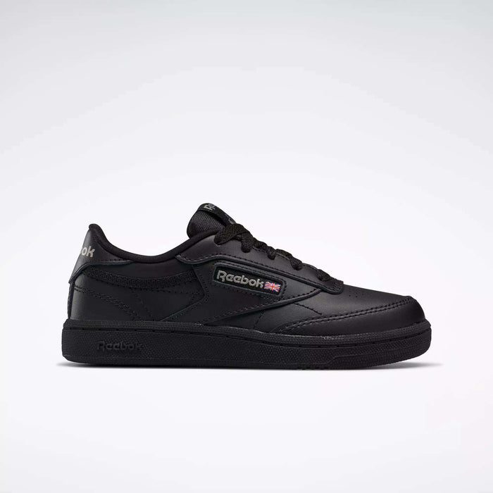 The Kids' Club C Shoes - Little Kids by Reebok are black low-top sneakers with a leather upper, Reebok logo and British flag on the side, black laces, and a black rubber sole, shown against a plain light gray background.