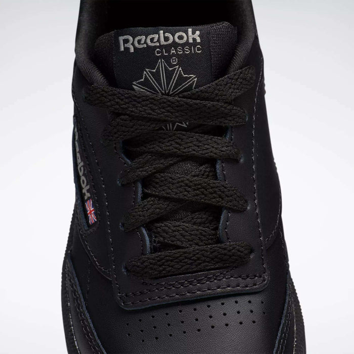 Close-up of black Reebok Kids' Club C Shoes for little kids, featuring black laces, the Reebok logo with Union Jack flag, and detailed stitching on the durable leather upper.