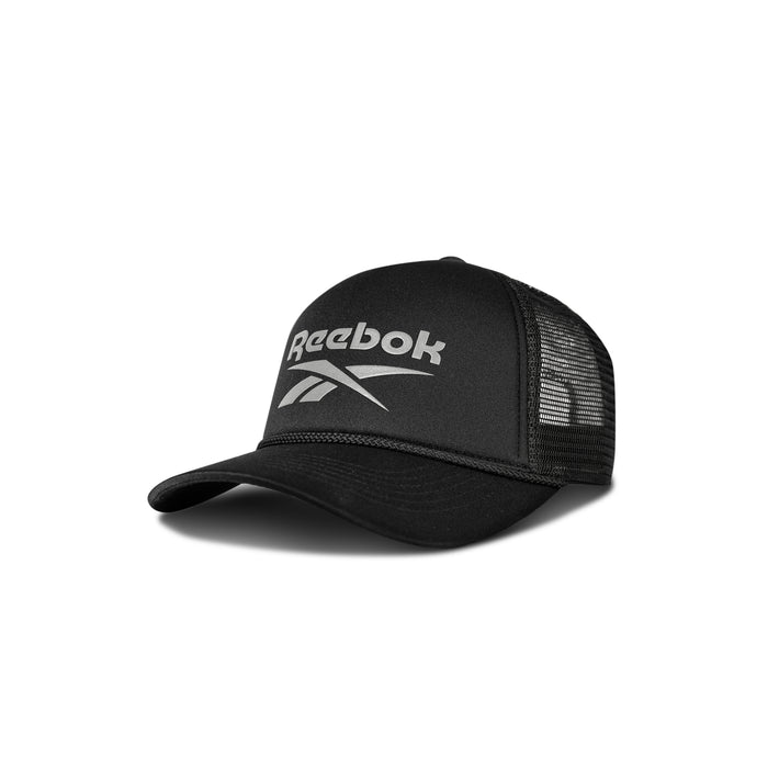 The Reebok Deluxe Aero Cap is a black trucker hat with mesh back panels, curved brim, adjustable snapback closure, and a white Reebok logo on the front. The cap is displayed against a white background.