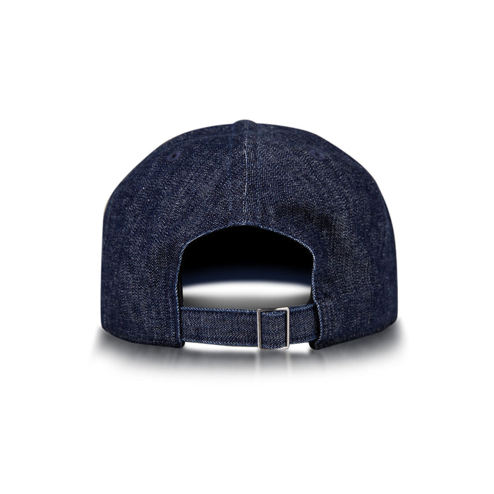 The Reebok Denim Badge Cap is shown from the back with an adjustable strap, metal buckle, and Speedwick sweatband. This dark blue cap appears on a white background with a subtle shadow beneath it.