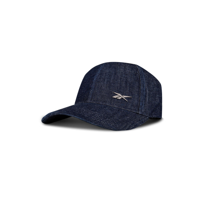 The Reebok Denim Badge Cap features durable dark blue denim, a curved brim, and a white embroidered logo on the front. It also includes a Speedwick sweatband to keep you cool, displayed on a white background with a subtle shadow.