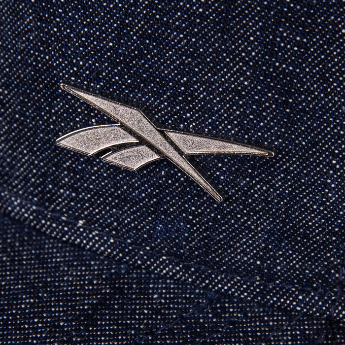 A metallic Reebok logo pin accents the textured blue Denim Badge Cap by Reebok, giving it a stylish edge.