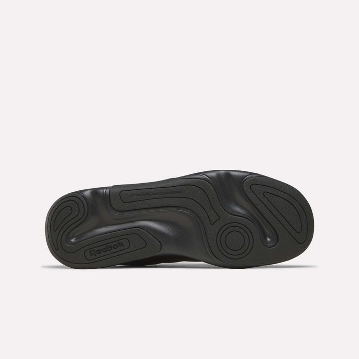 The Reebok DMX Comfort+ Classic walking shoe’s black sole, shown from the bottom against a plain white background, displays swirling tread patterns and textured grip zones, enhanced with dynamic air cushioning for exceptional comfort.