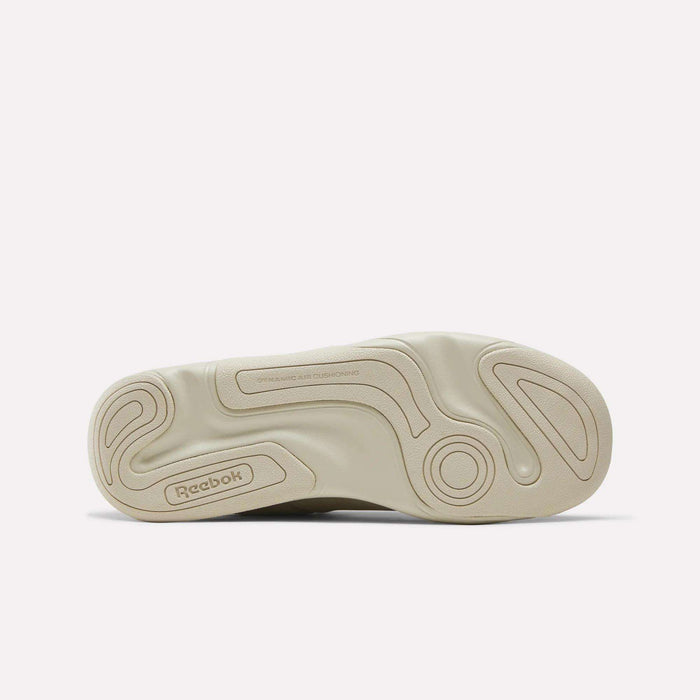 Beige Reebok DMX Comfort+ Classic sneaker sole facing up, showcasing a wavy textured pattern with the Reebok logo near the heel and visible dynamic air cushioning text near the arch.