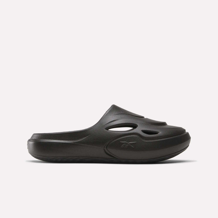 The Reebok DMX Recovery Mules are black slip-on shoes made from molded EVA, with cutout vents on the upper, a closed toe, and a chunky sole. Shown in side profile against a plain white background.