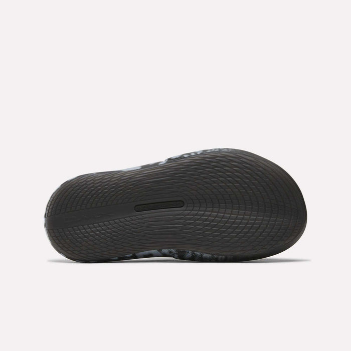 Close-up of the sole on Reebok DMX Recovery Mules, a black athletic shoe with DMX cushioning and wavy tread for excellent grip—perfect as recovery footwear after intense workouts.