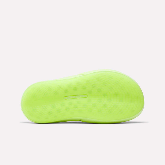 A neon green sole of the Reebok DMX Recovery Mules is shown from below against a white background. The molded EVA tread has a smooth finish with faint dots, suggesting DMX Moving Air tech.