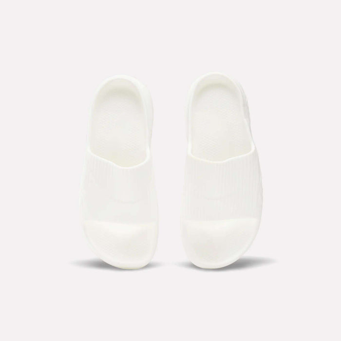 A pair of Reebok DMX Recovery Walking Slides in plain white are placed side by side on a light background, viewed from above.