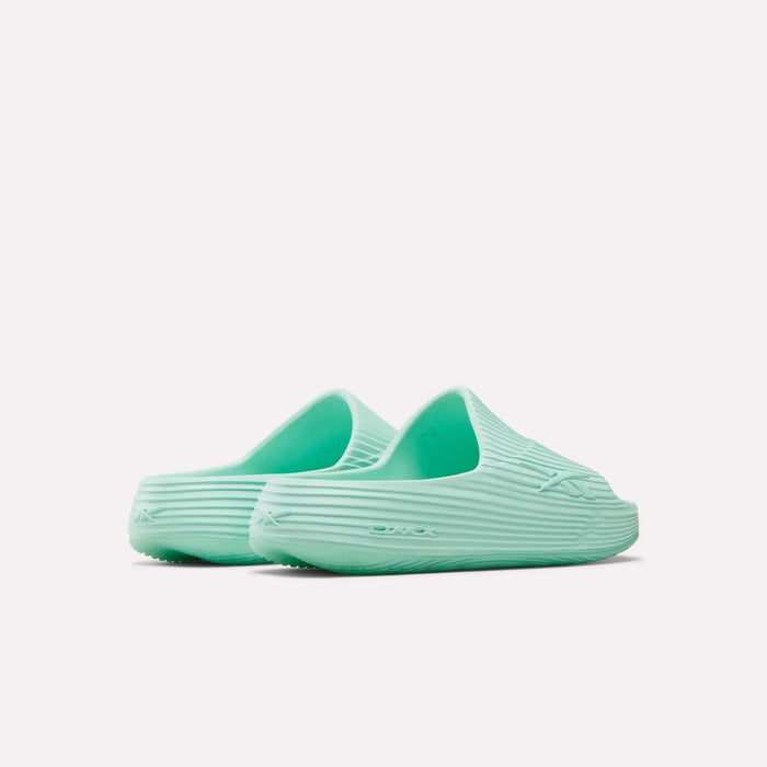 A pair of mint green Reebok DMX Recovery Walking Slides with a textured ribbed design and moving air cushioning, shown from the back and side on a plain white background.