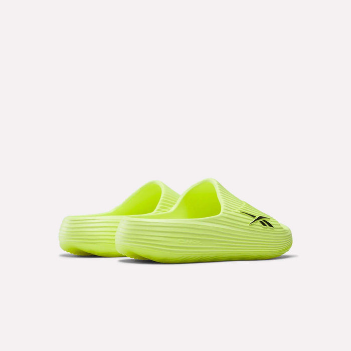 A pair of neon yellow Reebok DMX Recovery Walking Slides featuring ribbed textured soles, a black Reebok logo on one upper, and moving air cushioning for comfort. Shown against a plain white background.