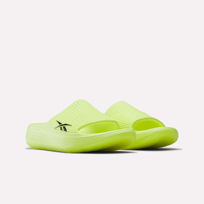 A pair of Reebok DMX Recovery Walking Slides in bright yellow with textured uppers and soles, a black Reebok logo on the side, and moving air cushioning, shown against a plain white background.