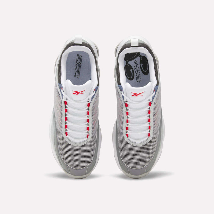 Top view of a pair of Reebok DMX Series 3000 Shoes in grey with white laces, red accents, and white soles, featuring DMX moving air technology for enhanced comfort, set against a plain light background.