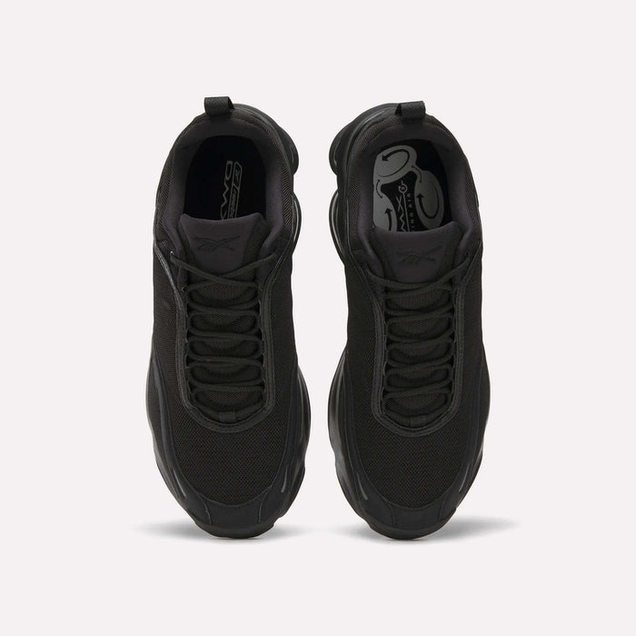 Top view of a pair of black Reebok DMX Series 3000 Shoes with mesh uppers, black laces, and thick soles featuring DMX moving air technology, placed side by side on a plain white background.