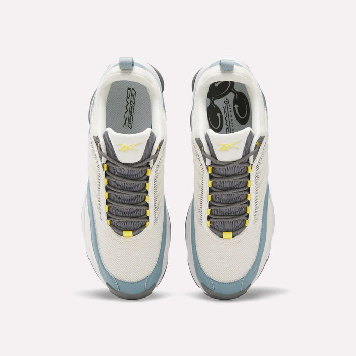Top view of white Reebok DMX Series 3000 Shoes with gray and blue accents, gray laces, and yellow details on the tongue and lace holes. Designed for comfort with DMX moving air technology, shown on a plain light background.