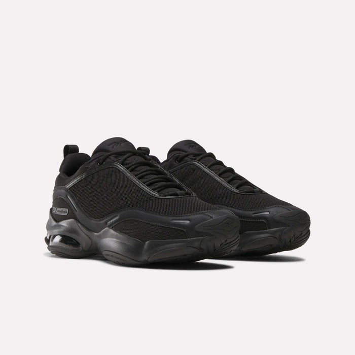 The Reebok DMX Series 3000 Shoes in black feature mesh uppers, thick rubber soles, subtle side branding, and DMX moving air technology for enhanced comfort—shown on a plain white background.
