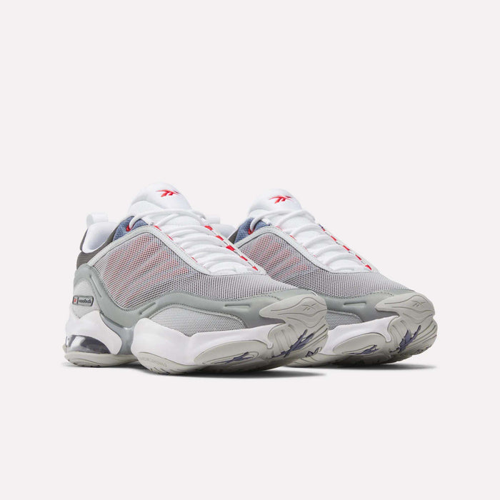 A pair of Reebok DMX Series 3000 Shoes in white, gray, and red with mesh uppers, chunky soles featuring DMX moving air technology for enhanced comfort, and prominent Reebok branding, displayed side by side on a light background.