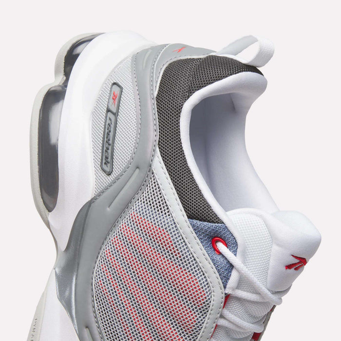 Close-up of the Reebok DMX Series 3000 Shoes—a modern athletic sneaker in white, grey, and red with mesh panels, red laces, a TX Control label on the side, and a visible heel air cushion featuring DMX moving air technology for superior comfort—an exciting new release from Reebok.