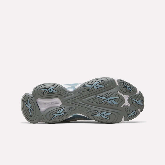 The image shows the bottom view of Reebok DMX Series 3000 Shoes featuring a gray rubber sole with blue accents and wavy geometric tread patterns designed for traction and comfort using DMX moving air technology.