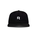 The Reebok Drop R Court Cap is a black baseball cap with a curved brim, showcasing a bold white "R" on the front. Photographed against a plain white background.