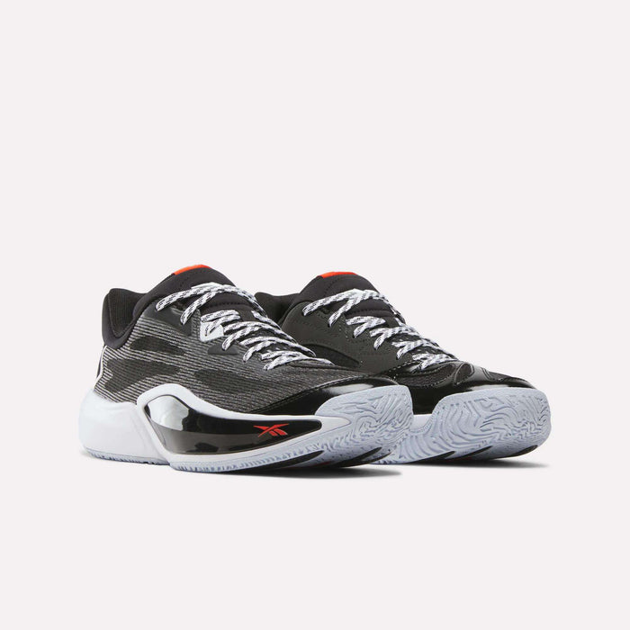 A pair of Reebok Engine A 26 Basketball Shoes featuring black engineered mesh uppers, white laces, red accents, a small red Reebok logo on the side, and textured white SuperFloat foam soles in a black and white low-top athletic sneaker design.