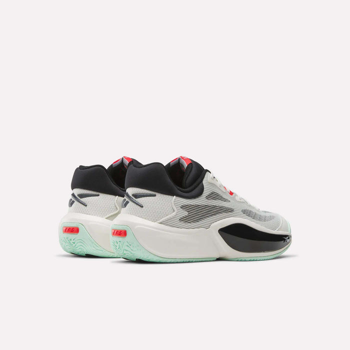 The Reebok Engine A 26 Basketball Shoes are white with black and red accents, featuring a translucent sole tinted mint green. Designed for stability and energy return, the pair is shown side by side to highlight their back and outer profiles.